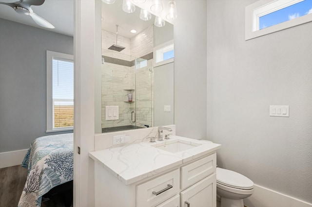 bathroom featuring ceiling fan, hardwood / wood-style floors, an enclosed shower, vanity, and toilet