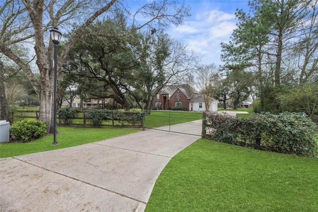 view of home's community with a fenced front yard, a gate, and a yard