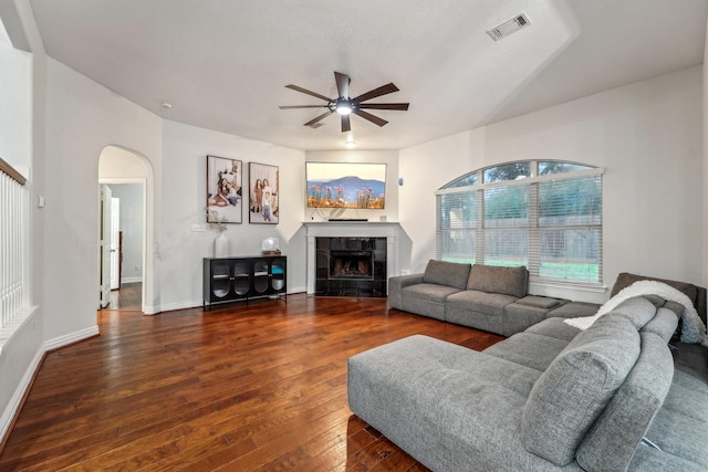 living room featuring a tile fireplace, wood-type flooring, and ceiling fan