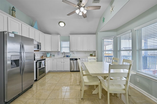 kitchen featuring white cabinetry, lofted ceiling, tasteful backsplash, and stainless steel appliances