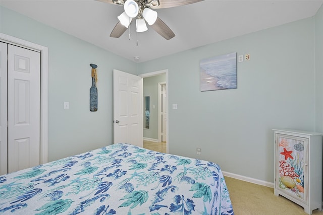 bedroom featuring ceiling fan, light carpet, and a closet