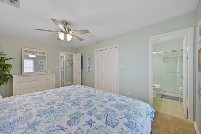 carpeted bedroom with a closet, connected bathroom, and ceiling fan