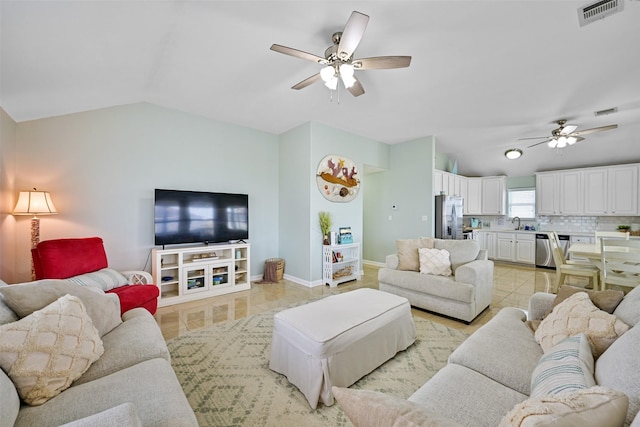 living room with lofted ceiling, light tile patterned floors, ceiling fan, and sink