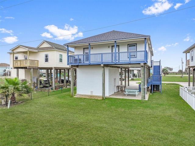 back of property featuring a deck, a patio, and a yard