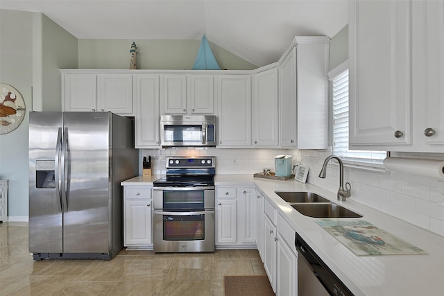 23178 Fresca St, Galveston, TX 77554 - kitchen with stainless steel appliances, a sink, lofted ceiling, white cabinets, and light countertops