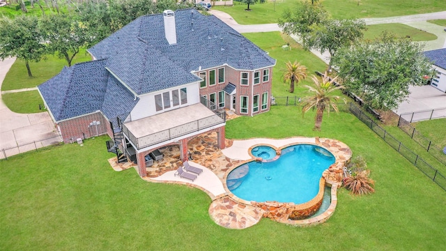 view of swimming pool with a patio area, a fenced backyard, a pool with connected hot tub, and a yard