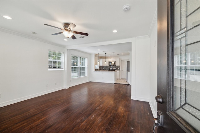 unfurnished living room featuring crown molding, ceiling fan, and dark hardwood / wood-style floors