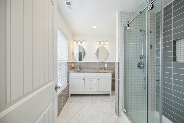 bathroom featuring vanity, tile walls, and a shower with shower door