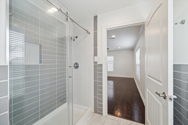 bathroom with crown molding and a tile shower