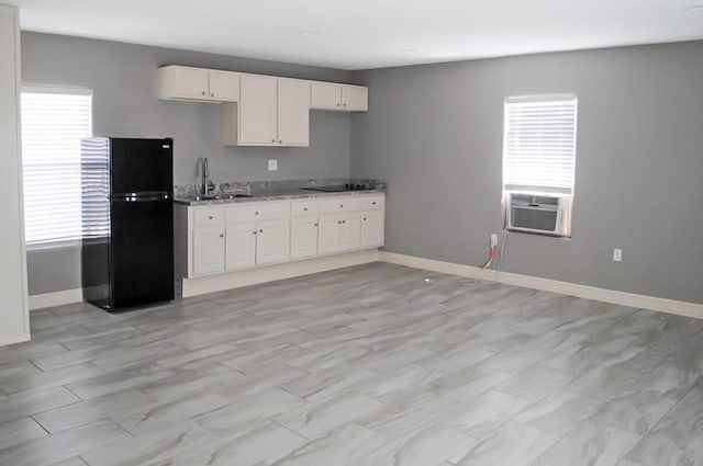 kitchen featuring sink, light stone counters, black appliances, cooling unit, and white cabinets