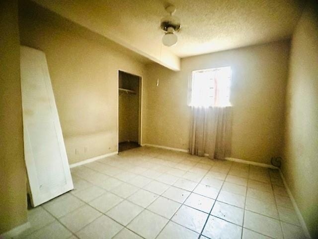 unfurnished room featuring light tile patterned floors and a textured ceiling