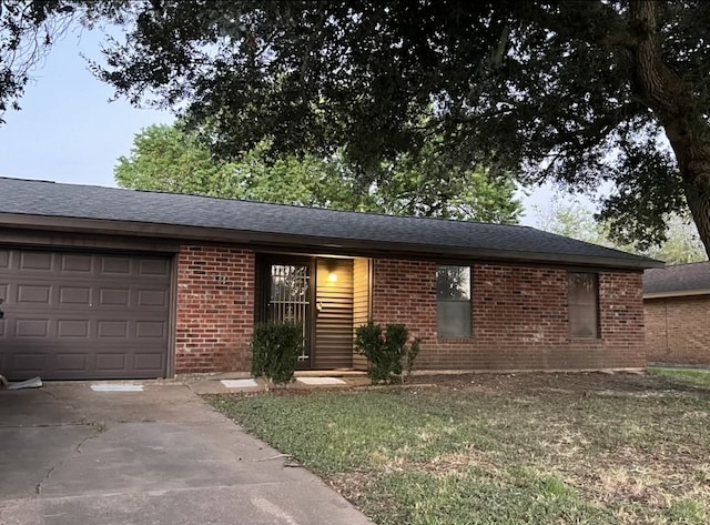 ranch-style home with a garage and a front lawn