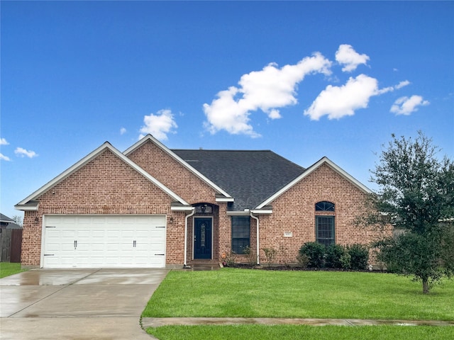 view of front of property featuring driveway, a front lawn, an attached garage, and brick siding