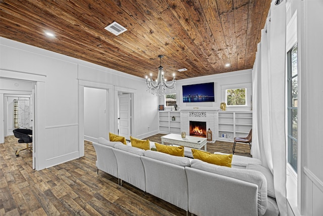 living room featuring dark wood-type flooring, a fireplace, a chandelier, and wooden ceiling