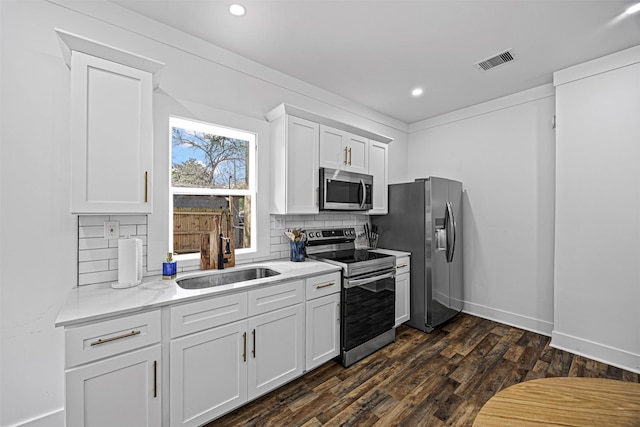 kitchen featuring sink, dark wood-type flooring, appliances with stainless steel finishes, tasteful backsplash, and white cabinets