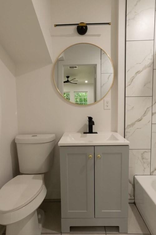 bathroom with vanity, a bath, ceiling fan, and toilet