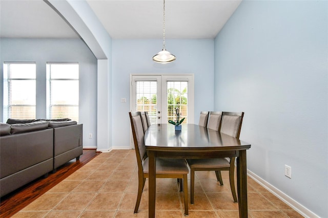 tiled dining space featuring french doors