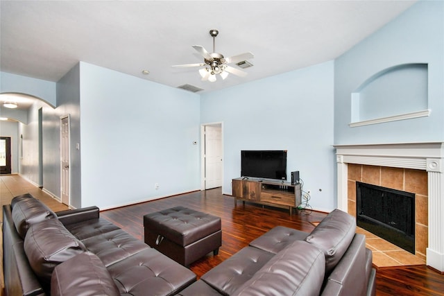 living room with ceiling fan, a fireplace, and hardwood / wood-style floors