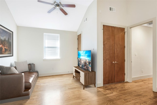 living room with ceiling fan, high vaulted ceiling, and light hardwood / wood-style flooring