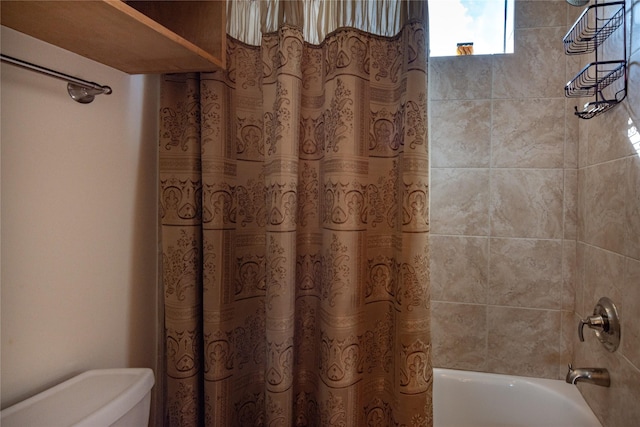 bathroom featuring shower / bath combination with curtain and toilet