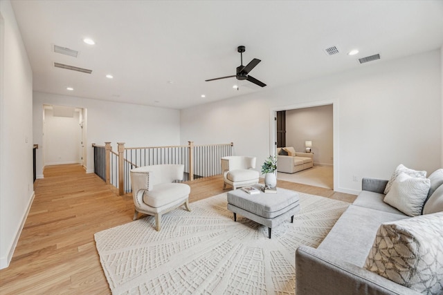 living room featuring light hardwood / wood-style flooring and ceiling fan