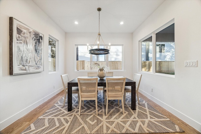 dining area featuring hardwood / wood-style flooring and an inviting chandelier