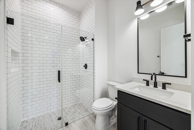 bathroom with walk in shower, vanity, and toilet