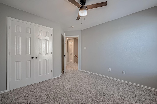 unfurnished bedroom with carpet, a closet, and ceiling fan