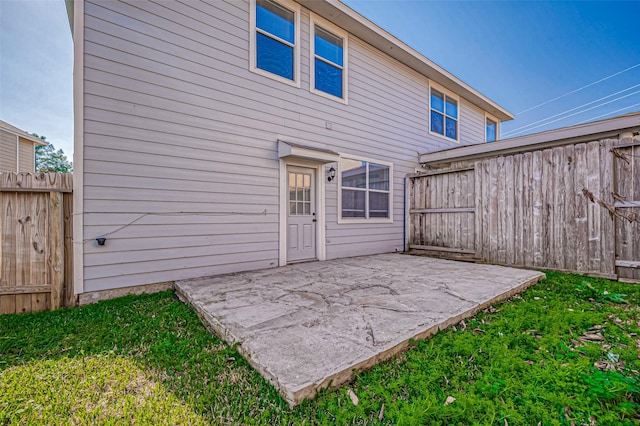 back of property featuring a patio area and a lawn