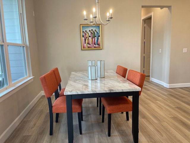 dining area featuring hardwood / wood-style flooring and an inviting chandelier