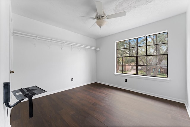 interior space with dark wood-type flooring and ceiling fan