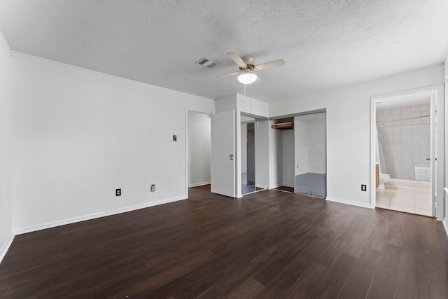 unfurnished bedroom featuring dark wood-type flooring, connected bathroom, a textured ceiling, a closet, and ceiling fan