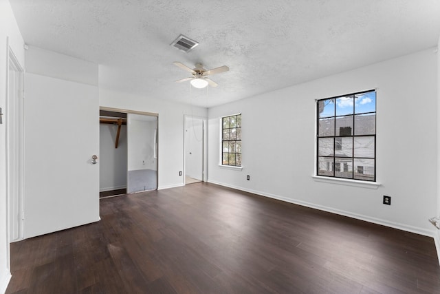 unfurnished bedroom featuring ceiling fan, dark hardwood / wood-style floors, and a textured ceiling