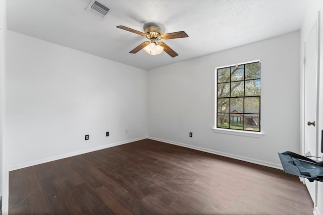 spare room with ceiling fan and dark hardwood / wood-style floors