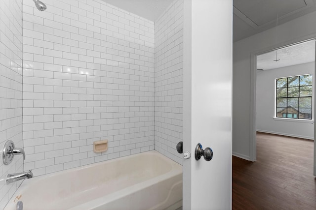 bathroom with tiled shower / bath combo and hardwood / wood-style flooring