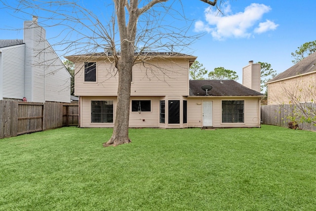 rear view of house featuring a lawn