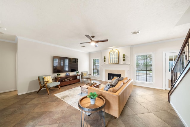 living area with ornamental molding, stairway, a fireplace, and visible vents