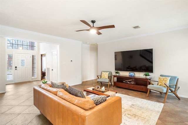 living area featuring light tile patterned floors, baseboards, visible vents, ceiling fan, and crown molding