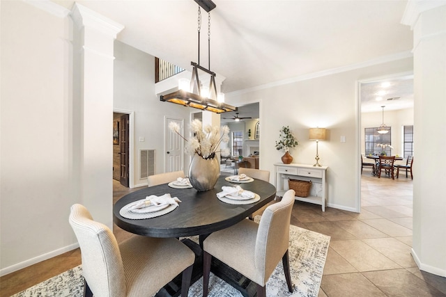 dining space with baseboards, light tile patterned floors, visible vents, and crown molding