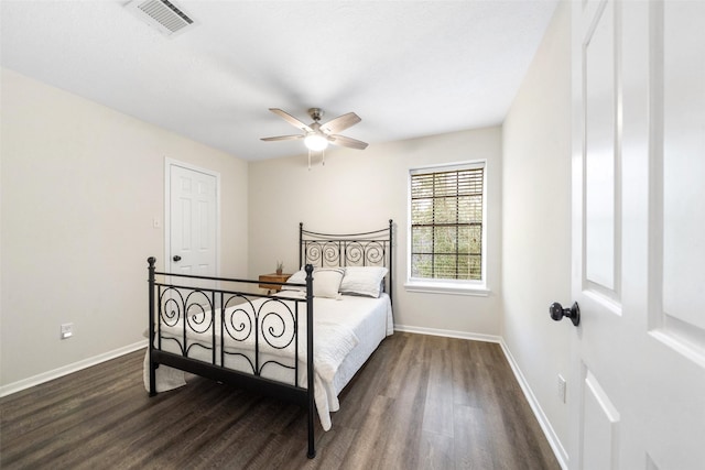 bedroom with dark wood-style floors, ceiling fan, visible vents, and baseboards