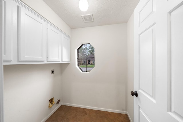 clothes washing area featuring cabinet space, baseboards, visible vents, a textured ceiling, and hookup for an electric dryer