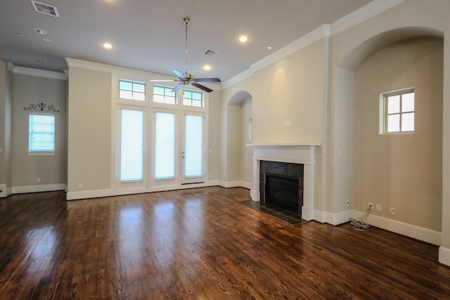 unfurnished living room with a wealth of natural light, ornamental molding, a tile fireplace, and dark hardwood / wood-style floors