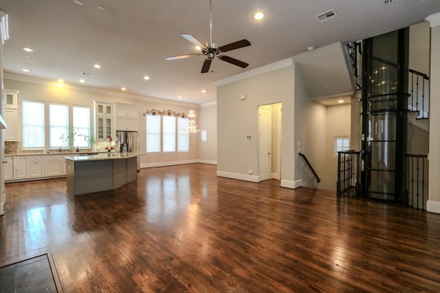 unfurnished living room with crown molding, dark hardwood / wood-style floors, and ceiling fan