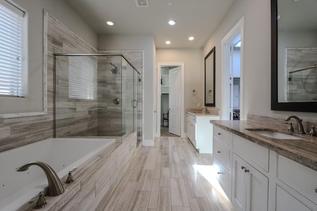 bathroom featuring vanity, hardwood / wood-style floors, and plus walk in shower