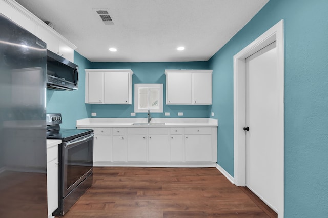 kitchen with appliances with stainless steel finishes, dark hardwood / wood-style floors, sink, and white cabinets