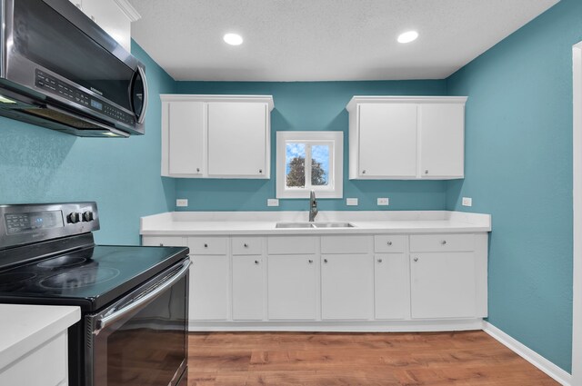 617 4th Ave N, Texas City, TX 77590 - kitchen featuring stainless steel appliances, light countertops, light wood finished floors, white cabinets, and recessed lighting