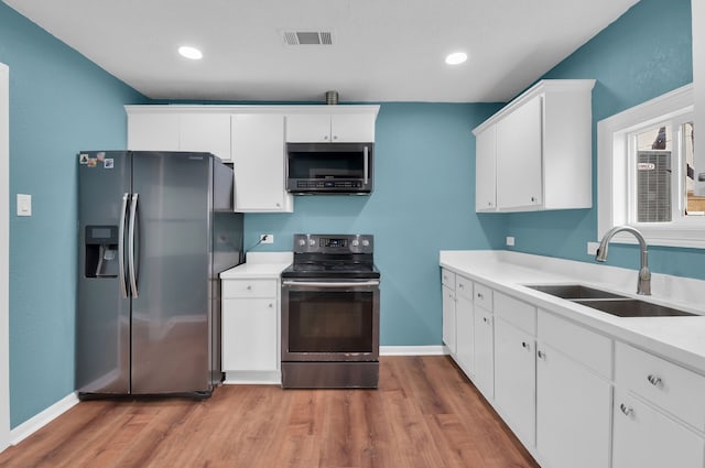617 4th Ave N, Texas City, TX 77590 - kitchen featuring stainless steel appliances, light wood-style floors, white cabinetry, light countertops, and recessed lighting