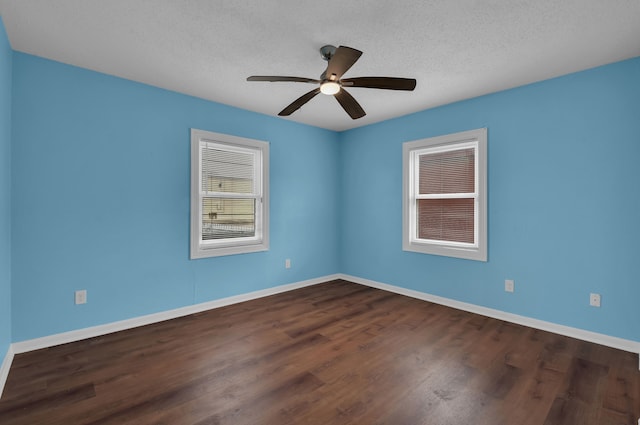 spare room featuring dark wood-type flooring, ceiling fan, and a textured ceiling