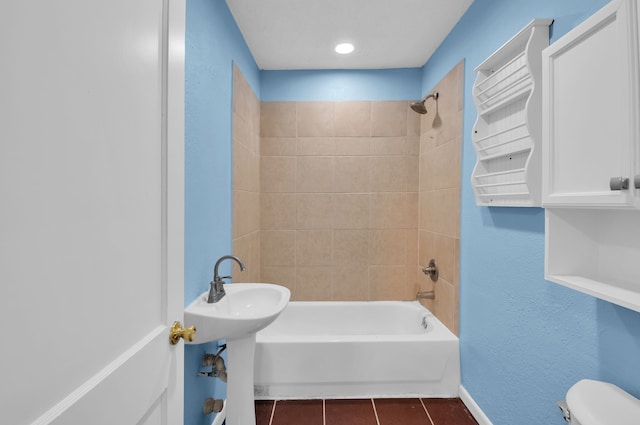 bathroom with tile patterned flooring, tiled shower / bath combo, and toilet