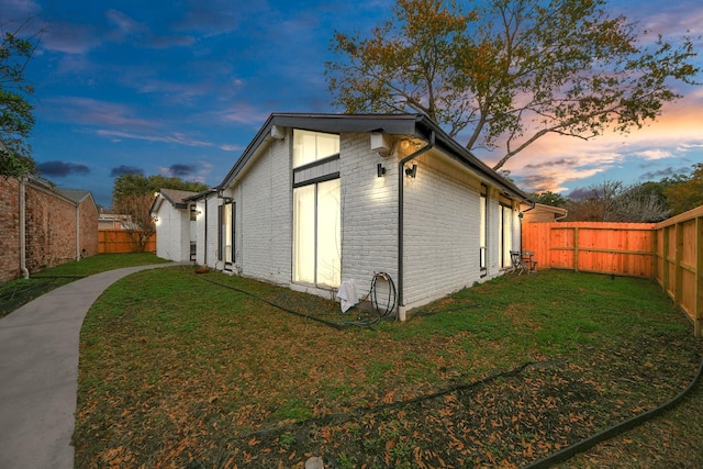 property exterior at dusk with a yard